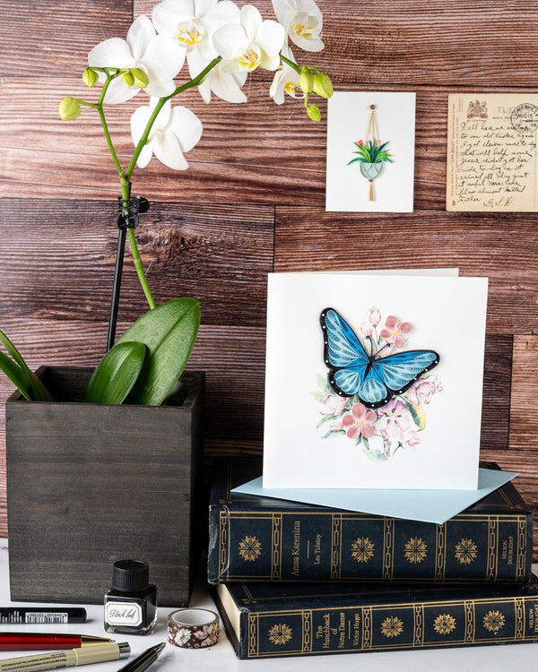 Carte de vœux papillon bleu et fleurs roses en papier roulé