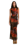 Modèle portant une jupe longue fluide La Maison du Bleuet à motif floral rouge et orange sur fond brun